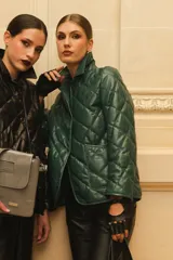 Campera de cuero negra con diseño matelassé de rombos, cuello camisero, cierre frontal con botones a presión, dos bolsillos delanteros y puños con botón.
