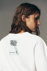 Camiseta blanca de algodón, corte boxy fit, cuello redondo, manga corta y etiqueta contrastante en la espalda.
