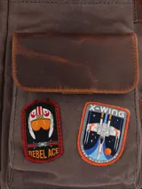 Mochila de lona color marrón con detalles en cuero color marrón oscuro. Tiene un compartimento principal con cierre de cremallera y solapa con broche imantado, bolsillo acolchado interior para laptop de 15", bolsillo interior con cierre, un bolsillo frontal con cierre, bolsillos laterales, pasador en la parte de atrás para maleta, bolsillo trasero con cierre cremallera, correas ajustables y forro interior con diseño Star Wars.