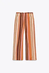 Pantalón de tiro medio con estampado de rayas verticales en tonos marrón, naranja, rosa y beige. Cuenta con trabillas en la cintura, cinturón ajustable con lazadas, bolsillos laterales y cierre frontal con cremallera y botones.