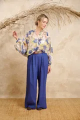 Pantalón ancho color beige de lino con cinto y pretina con elástico en la parte de atrás.