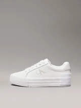 Zapatillas urbanas Calvin Klein Jeans de cuero sintético color blanco, con plataforma plana, cordones y logo CK en el lateral.