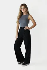 Pantalón negro de tiro alto, corte palazzo y bolsillos laterales.
