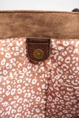 Bolso tipo tote de gamuza vegana color camel, con asas de mano y logo grabado en el frente.