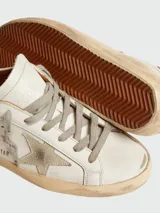 Championes Golden Goose modelo Super Star, color blanco con detalles en marrón y estrella en gris.