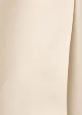 Pantalón de vestir color crema, de corte flare y tiro medio. Presenta cierre frontal con botón, gancho y cremallera oculta, trabillas, bolsillos laterales y bolsillos de ribete en la parte posterior.