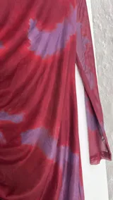 Vestido midi de microtul doble, color borgoña con estampado difuminado en tonos lila. Tiene cuello alto y mangas largas de una sola capa de microtul.