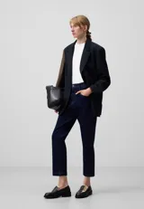 Pantalón tobillero de denim azul oscuro, con pespuntes a contraste, cierre con botón metálico, trabillas, cinco bolsillos y corte flare.