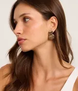 Aros de metal reciclado color dorado con forma geométrica y textura de ondas.