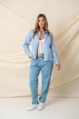 Camisa celeste de napa ecológica con detalle de tachas plateadas, corte recto y puños anchos.