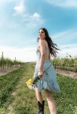 Vestido corto celeste con breteles finos, espalda descubierta con detalle de encaje y volados en el ruedo.