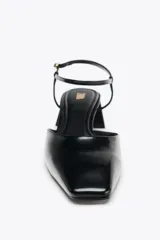 Zapato de tacón ancho color negro con efecto charol, destalonado y con pulsera al tobillo con cierre de hebilla.