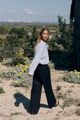 Pantalón azul marino de lino, de tiro alto con cintura elástica ajustable con cordones, bolsillos delanteros y pernera recta.