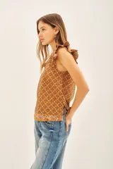 Camisa color marrón con estampado geométrico, escote redondo, mangas cortas con volados estampados y tajos laterales.