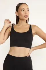 Top deportivo negro con breteles finos cruzados en la espalda y almohadillas removibles.