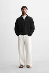 Sudadera negra de cuello alto con cierre de cremallera, corte regular y mangas largas.