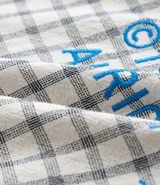 Camisa de hombre de manga corta, cuello inglés y corte boxy, confeccionada en algodón tricolina texturizada a cuadros. Presenta abotonado frontal y bordado en la espalda.