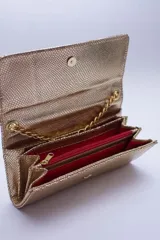 Cartera tipo sobre color beige con textura granulada y correa de cadena dorada.