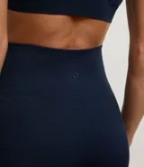 Conjunto deportivo de dos piezas, compuesto por un top deportivo de tirantes anchos y un pantalón legging de tiro alto. Ambas prendas son de color azul marino oscuro y están confeccionadas en tejido rib seamless acanalado.