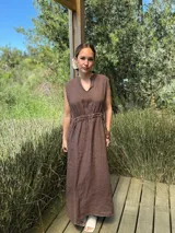 Vestido marrón de lino, corte midi, sin mangas, con cuello mao y cintura elastizada.