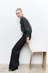 Pantalón de jean negro de tiro alto con trabillas en la cintura, corte bootcut y cinco bolsillos.