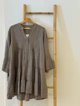 Vestido corto negro de lino, con escote en V, botones frontales y mangas largas acampanadas con volados.