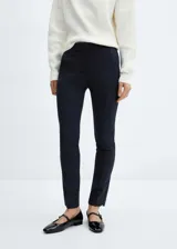 Pantalón negro de diseño crop, corte skinny y tiro medio. Cuenta con trabillas, dos bolsillos laterales, dos bolsillos de ribete en la parte posterior, cierre de cremallera y botón, y forro interior.