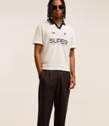 Pantalón de vestir marrón oscuro, de corte loose, con pliegues, bolsillos laterales y traseros.