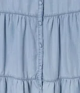 Pollera midi de liocel celeste, con corte evasé y tres niveles de volantes. Presenta abotonadura frontal completa y ruedo desflecado.