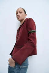Blazer color borgoña confeccionado en piel de ante. Tiene cuello solapa de muescas, manga larga, bolsillos de vivo en delantero, forro interior y cierre frontal con botones.