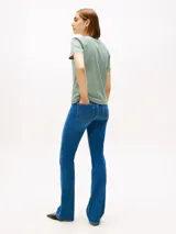 Remera de manga corta con cuello redondo y ribete en color verde oscuro. Presenta un patrón de rayas horizontales alternadas en blanco y verde. Tiene un pequeño logo circular bordado en blanco en el centro del pecho.