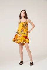Vestido corto amarillo con estampado de flores, breteles finos y cuello redondo.