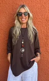 Buzo oversize color marrón chocolate, con cuello redondo y mangas largas que se pueden remangar.