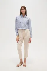 Pantalón de algodón color beige, de corte recto y largo a media pierna.