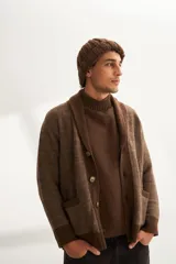 Cardigan tejido color marrón con cuello smoking, cierre con botones y bolsillos delanteros.