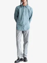 Camisa celeste de manga larga con cuello clásico, cierre frontal con botones, bolsillo de parche en el pecho y logo de Calvin Klein bordado en el bolsillo.