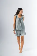 Conjunto de pijama de algodón estampado con flores, compuesto por una musculosa de escote recto con frunces y un short con elástico en la cintura y volados en el ruedo.