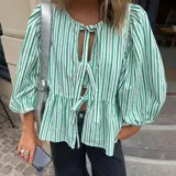 Blusa de mangas 3/4 abullonadas con elástico en los puños, con estampado a rayas verticales verdes y blancas. Tiene escote redondo con abertura en forma de gota y lazos para atar.