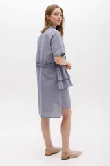 Vestido camisero a rayas con cuello y cartera en tono lima claro, volados frontales y laterales. De calce relajado y mangas cortas. Fabricado en Uruguay.