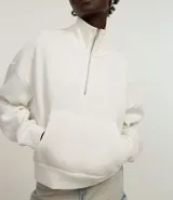 Buzo blanco de algodón con forro polar, cuello alto con cremallera, bolsillo canguro y mangas largas con puños ajustados.