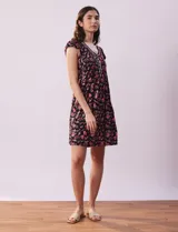 Camisón corto negro con estampado de lunares blancos, escote en V con puntilla blanca y botones.