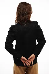 Camisa blanca de lino con corte clásico, cuello camisero, mangas largas con puños abotonados y volados en los hombros.