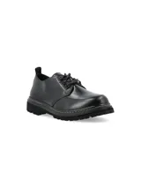 Zapato acordonado de cuero negro con suela track y detalle de pespuntes en color crudo.