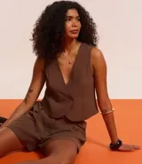 Short verde esmeralda de cintura alta, corte sastrero, con trabillas, pliegues y bolsillos. Incluye cinturón de tela con hebilla redonda.