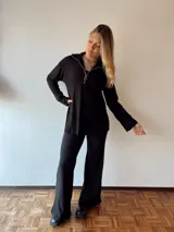 Pantalón negro acampanado de tejido de punto acanalado con cintura elástica.