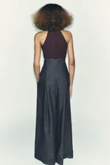 Top negro de cuello halter con cierre de botones en la parte trasera del cuello y espalda descubierta.