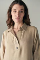 Vestido largo color beige de lino, con cuello camisero, media cartera con un botón, mangas 3/4 con tajos y bolsillos laterales.