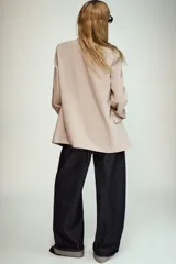 Blazer negro de manga larga con cuello solapa y cierre frontal de un solo botón. Presenta bolsillos delanteros con solapas.