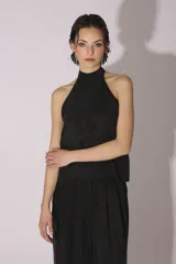 Conjunto de blusa y pantalón color gris azulado de seda, con cuello halter y corte holgado.