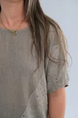 Blusa color visón de lino con mangas cortas, escote redondo y detalle de bordado calado en diagonal.